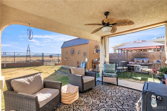 view of patio / terrace featuring a ceiling fan, a fenced backyard, an outdoor living space, and a gazebo