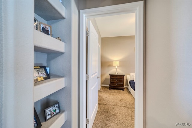 corridor featuring light carpet and baseboards