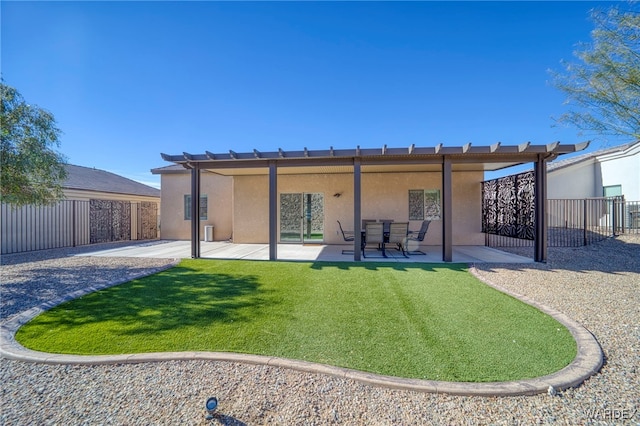 rear view of property featuring a yard, a patio, fence, and stucco siding