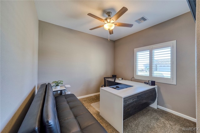 carpeted office space with baseboards, visible vents, and a ceiling fan