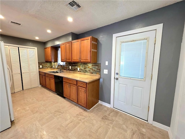 3166 E Thompson Ave, Kingman, AZ 86409 - kitchen featuring a sink, dishwasher, light countertops, freestanding refrigerator, and brown cabinetry