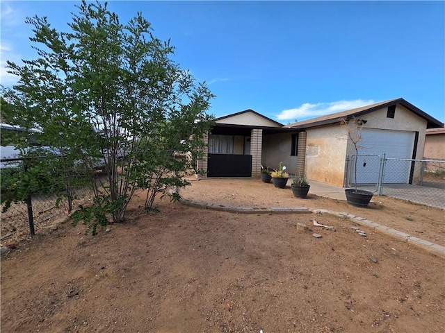 3166 E Thompson Ave, Kingman, AZ 86409 - view of front of property featuring a garage, stucco siding, driveway, and a gate
