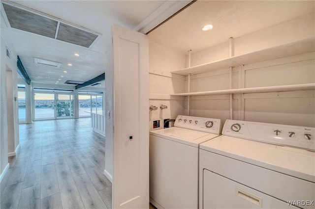 clothes washing area with laundry area, light wood finished floors, visible vents, washer and dryer, and recessed lighting