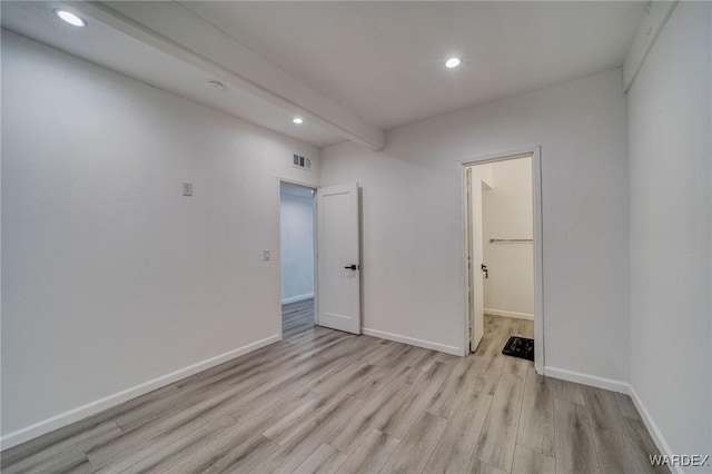 unfurnished room with light wood finished floors, beamed ceiling, recessed lighting, and baseboards