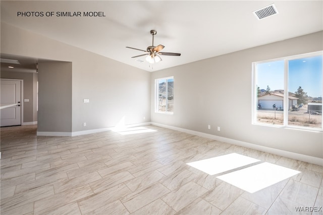 unfurnished room featuring vaulted ceiling, ceiling fan, visible vents, and baseboards