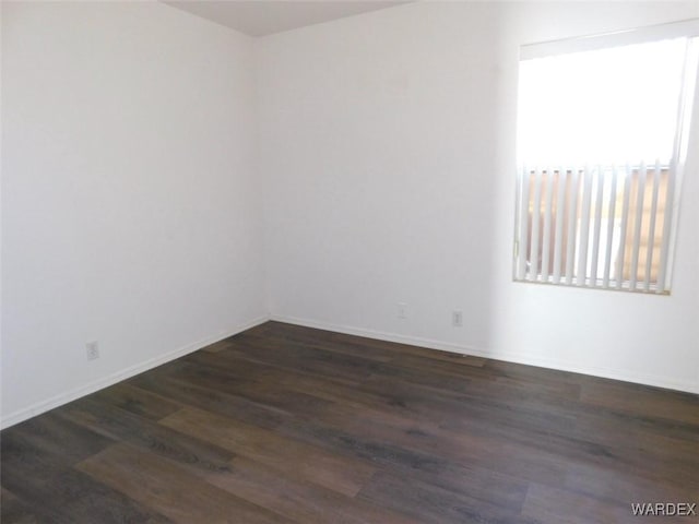 unfurnished room featuring dark wood finished floors and baseboards