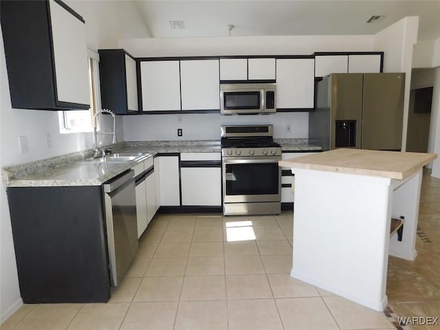 kitchen with appliances with stainless steel finishes, light countertops, visible vents, and white cabinetry