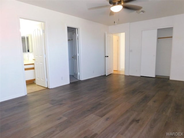 unfurnished bedroom with a closet, visible vents, a ceiling fan, wood finished floors, and baseboards