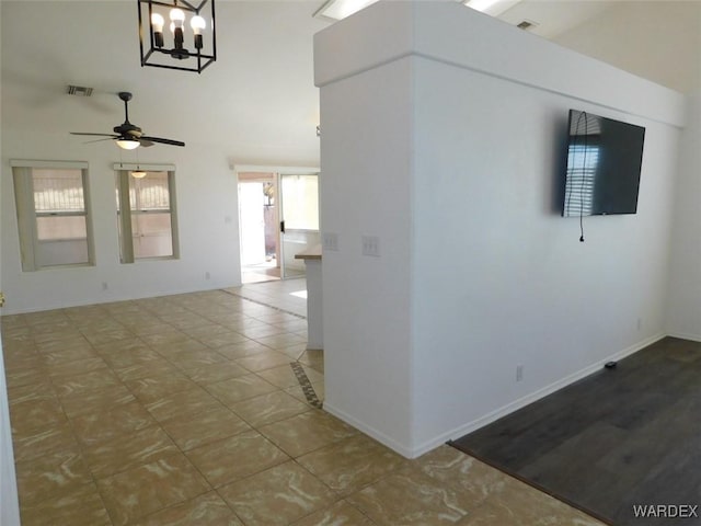 empty room with a ceiling fan, visible vents, and baseboards