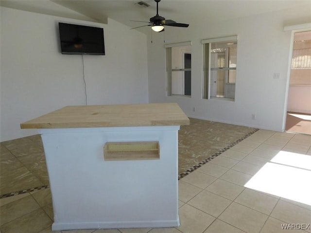 kitchen featuring a kitchen island, visible vents, ceiling fan, and light tile patterned floors