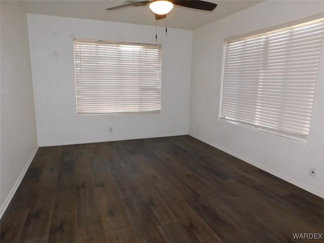 spare room with a wealth of natural light, baseboards, a ceiling fan, and wood finished floors