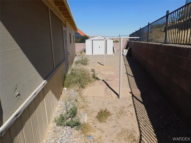 view of yard with an outbuilding, fence, and a shed