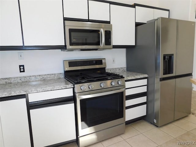 kitchen with white cabinetry, appliances with stainless steel finishes, and light tile patterned flooring