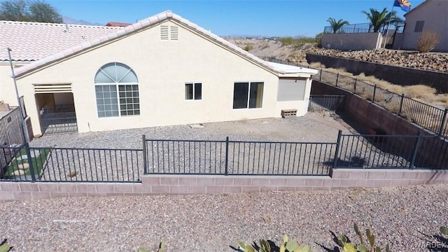 back of property with fence, a patio, and stucco siding