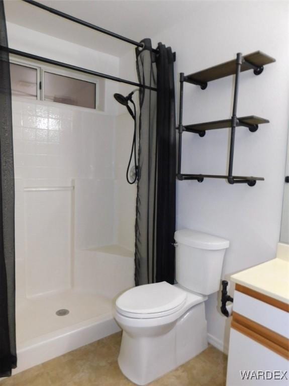 bathroom with toilet, a stall shower, and vanity