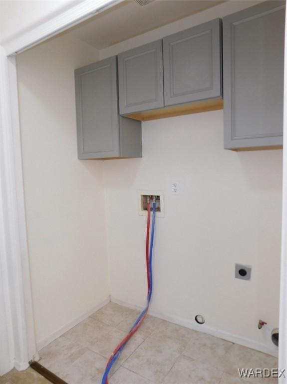 clothes washing area with hookup for a washing machine, hookup for an electric dryer, hookup for a gas dryer, baseboards, and cabinet space