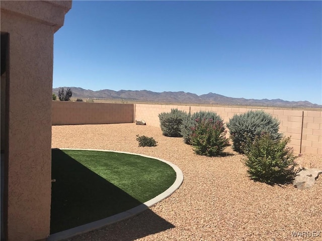 view of yard featuring a fenced backyard and a mountain view