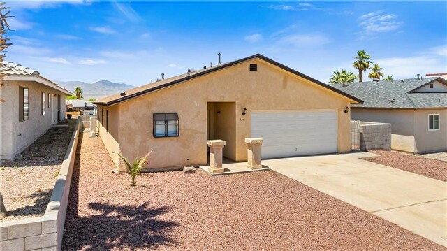 3741 June St, Bullhead City, AZ 86442 - view of front of property featuring a mountain view, stucco siding, a garage, and concrete driveway