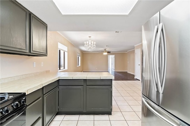 3741 June St, Bullhead City, AZ 86442 - kitchen with freestanding refrigerator, black gas stove, a peninsula, a chandelier, and healthy amount of natural light