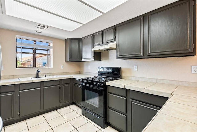 3741 June St, Bullhead City, AZ 86442 - kitchen featuring gas stove, under cabinet range hood, a sink, light tile patterned flooring, and light countertops