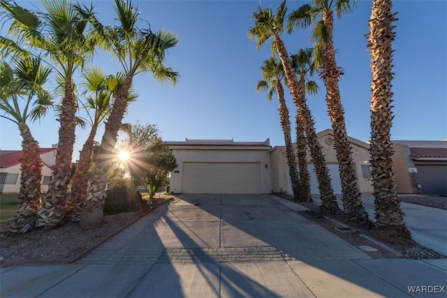 view of front of property featuring a garage, concrete driveway, and stucco siding