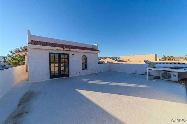 back of house with a patio, a tile roof, french doors, stucco siding, and ac unit