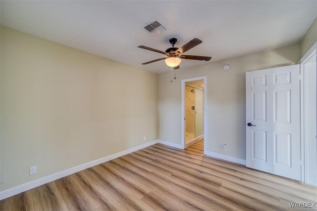 unfurnished bedroom featuring baseboards, visible vents, ceiling fan, ensuite bathroom, and light wood-type flooring