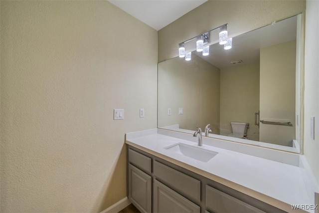 bathroom featuring toilet, visible vents, and vanity