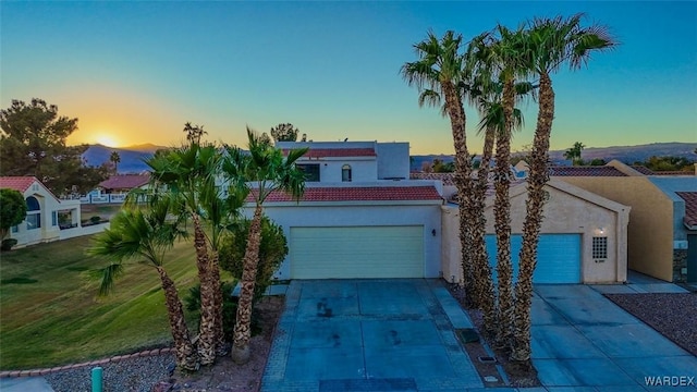 mediterranean / spanish-style home with a garage, concrete driveway, and stucco siding