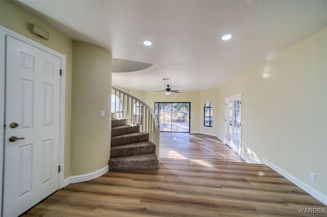 entryway with recessed lighting, wood finished floors, baseboards, and stairs