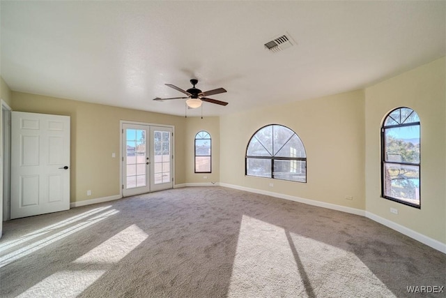 empty room with light carpet, baseboards, visible vents, and french doors