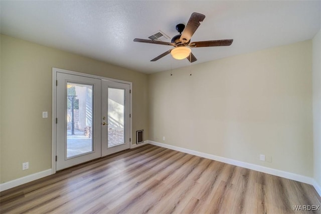 empty room with ceiling fan, visible vents, light wood-style floors, baseboards, and french doors