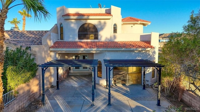 rear view of property featuring a tiled roof, a carport, and stucco siding