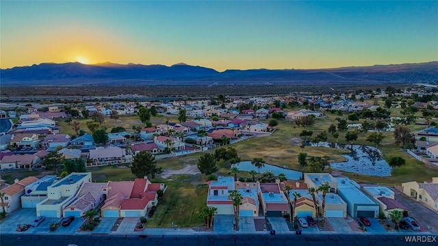 aerial view at dusk featuring a residential view and a mountain view