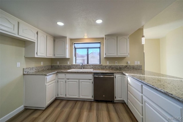 kitchen with dark wood-type flooring, white cabinets, a sink, light stone countertops, and dishwasher