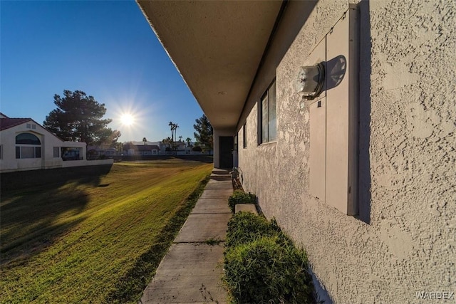 view of property exterior featuring a lawn and stucco siding