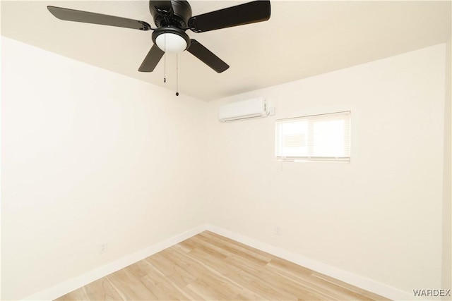 empty room with baseboards, an AC wall unit, and wood finished floors