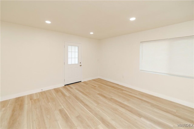 unfurnished room featuring baseboards, wood finished floors, and recessed lighting