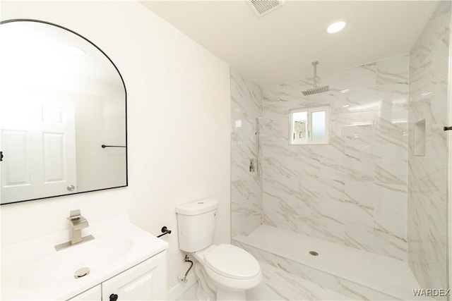 bathroom featuring toilet, a marble finish shower, visible vents, and vanity