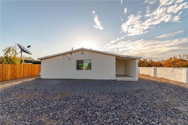 exterior space with a fenced backyard and stucco siding