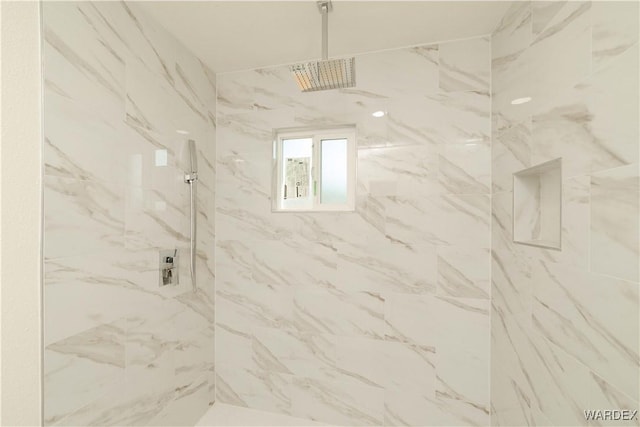 bathroom featuring a marble finish shower