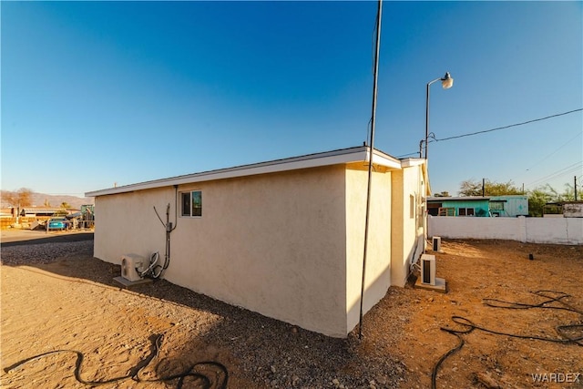 view of property exterior with fence and stucco siding