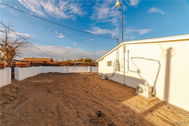 view of yard with ac unit and fence