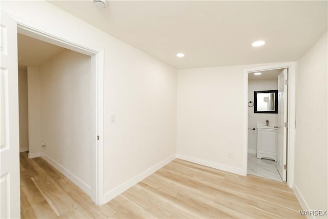 empty room with baseboards, wood finished floors, and recessed lighting