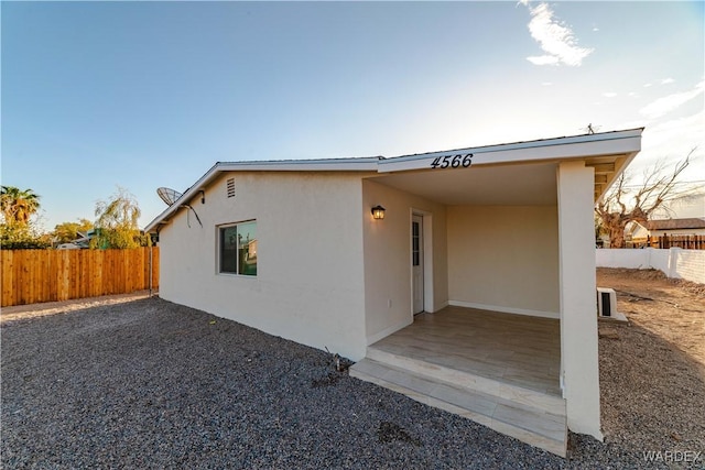 view of side of property with fence and stucco siding