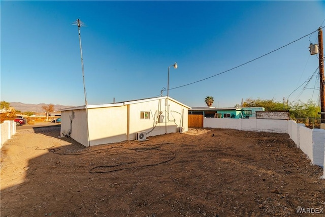 rear view of house featuring fence and a mountain view