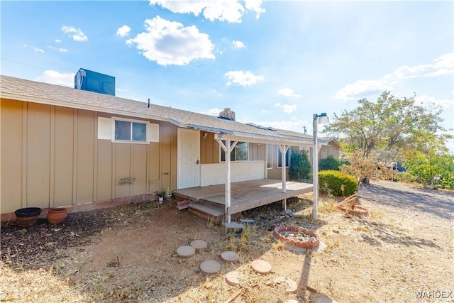 rear view of property featuring a deck and board and batten siding