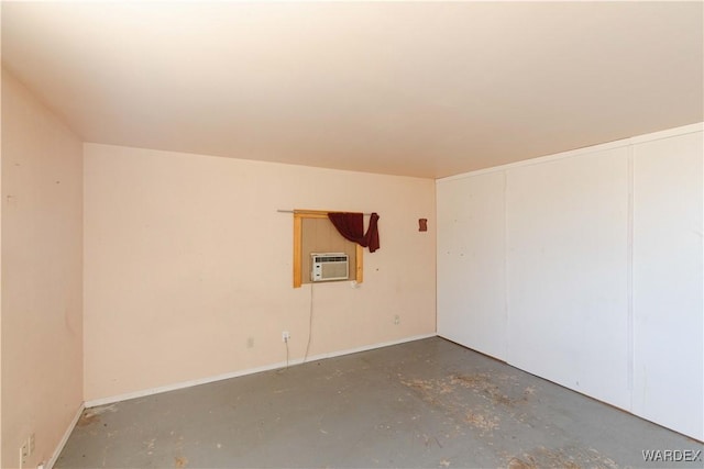 spare room with a wall mounted AC and unfinished concrete floors