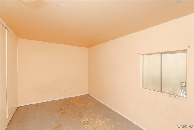 unfurnished room featuring unfinished concrete flooring and baseboards