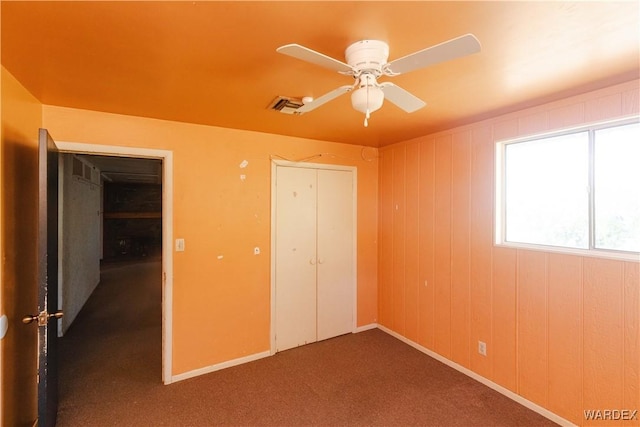 unfurnished bedroom featuring a closet, visible vents, carpet flooring, ceiling fan, and baseboards